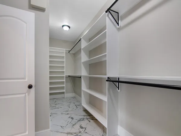 a view of walk in closet with empty racks