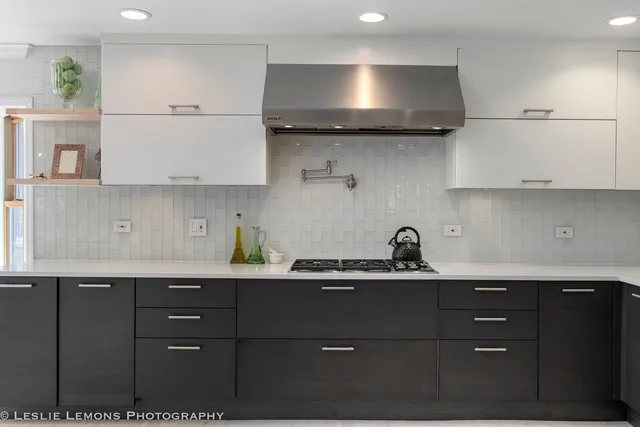 a living room with stainless steel appliances kitchen island granite countertop a refrigerator and a stove top oven