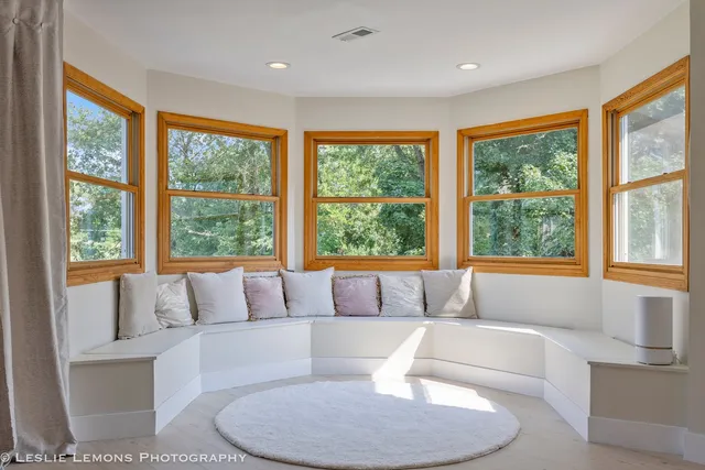 a view of an empty room with furniture and a window
