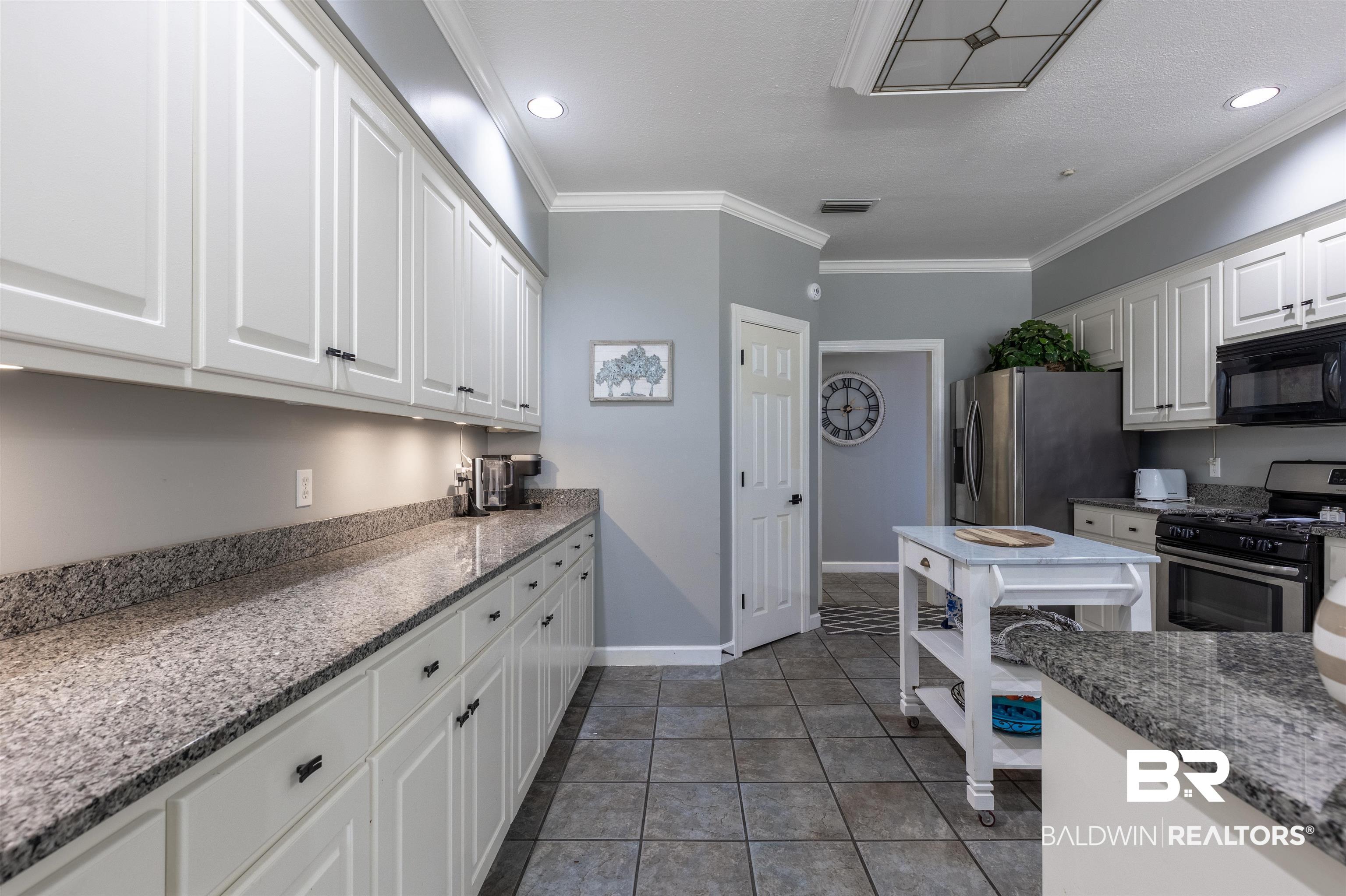 6436 Cherry Ridge Court West Mobile, AL 36695 - Photo 17 of 26 Kitchen with white cabinetry, ornamental molding, appliances with stainless steel finishes, and tile patterned flooring