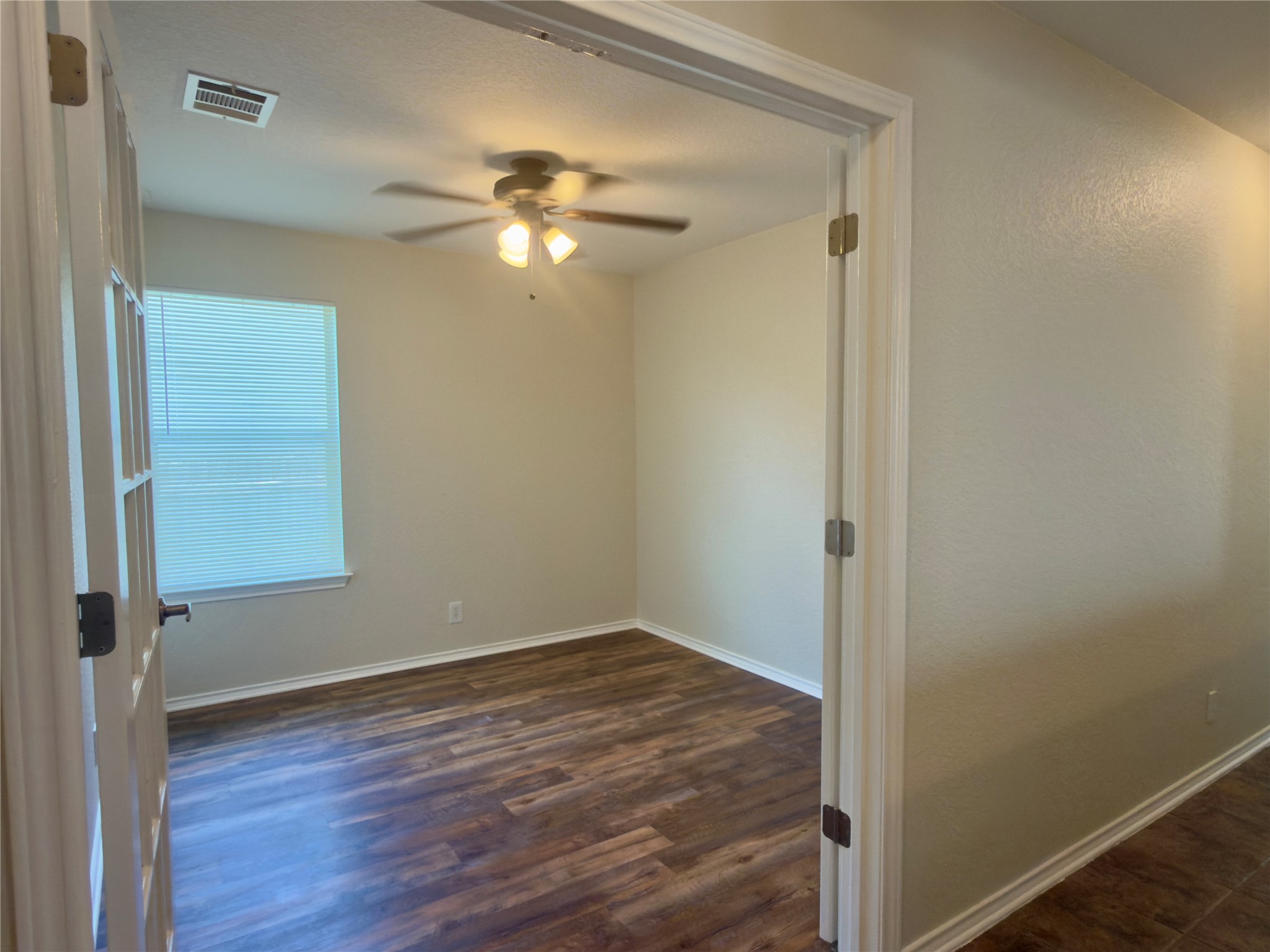 255 Myrtle Street Kyle, TX 78640 - Photo 12 of 31 Room featuring wood-finish flooring, a ceiling fan with integrated lighting, window with blinds, and neutral wall tones