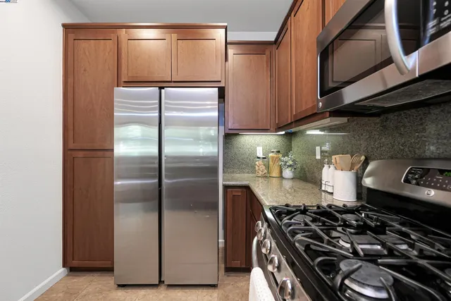 a kitchen with a refrigerator and a stove top oven