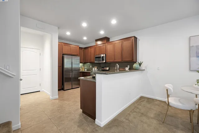 a kitchen with stainless steel appliances granite countertop a refrigerator and a stove top oven