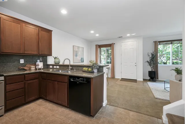 a kitchen with granite countertop a sink and cabinets