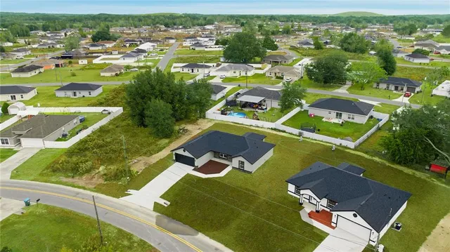 an aerial view of residential houses with outdoor space and city view