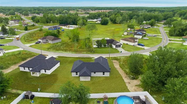 an aerial view of residential houses with outdoor space and swimming pool