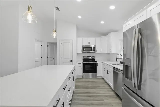 a kitchen with stainless steel appliances a refrigerator sink and microwave