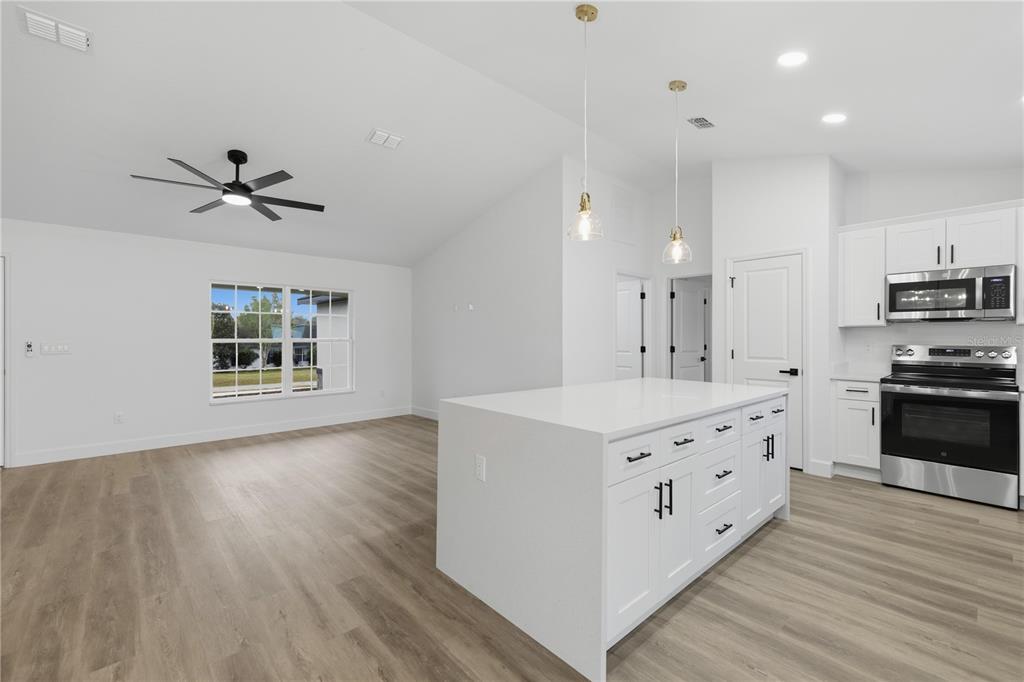 23 Juniper Loop Court Ocala, FL 34480 - Photo 8 of 25 a kitchen with stainless steel appliances sink cabinets and wooden floor