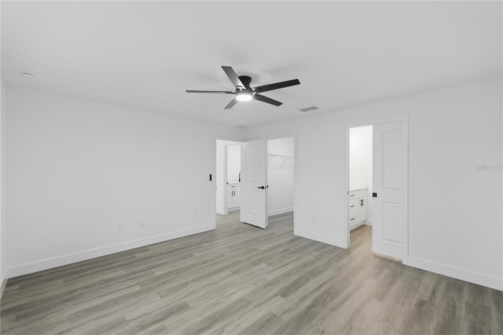 23 Juniper Loop Court Ocala, FL 34480 - Photo 10 of 25 an empty room with wooden floor and ceiling fan