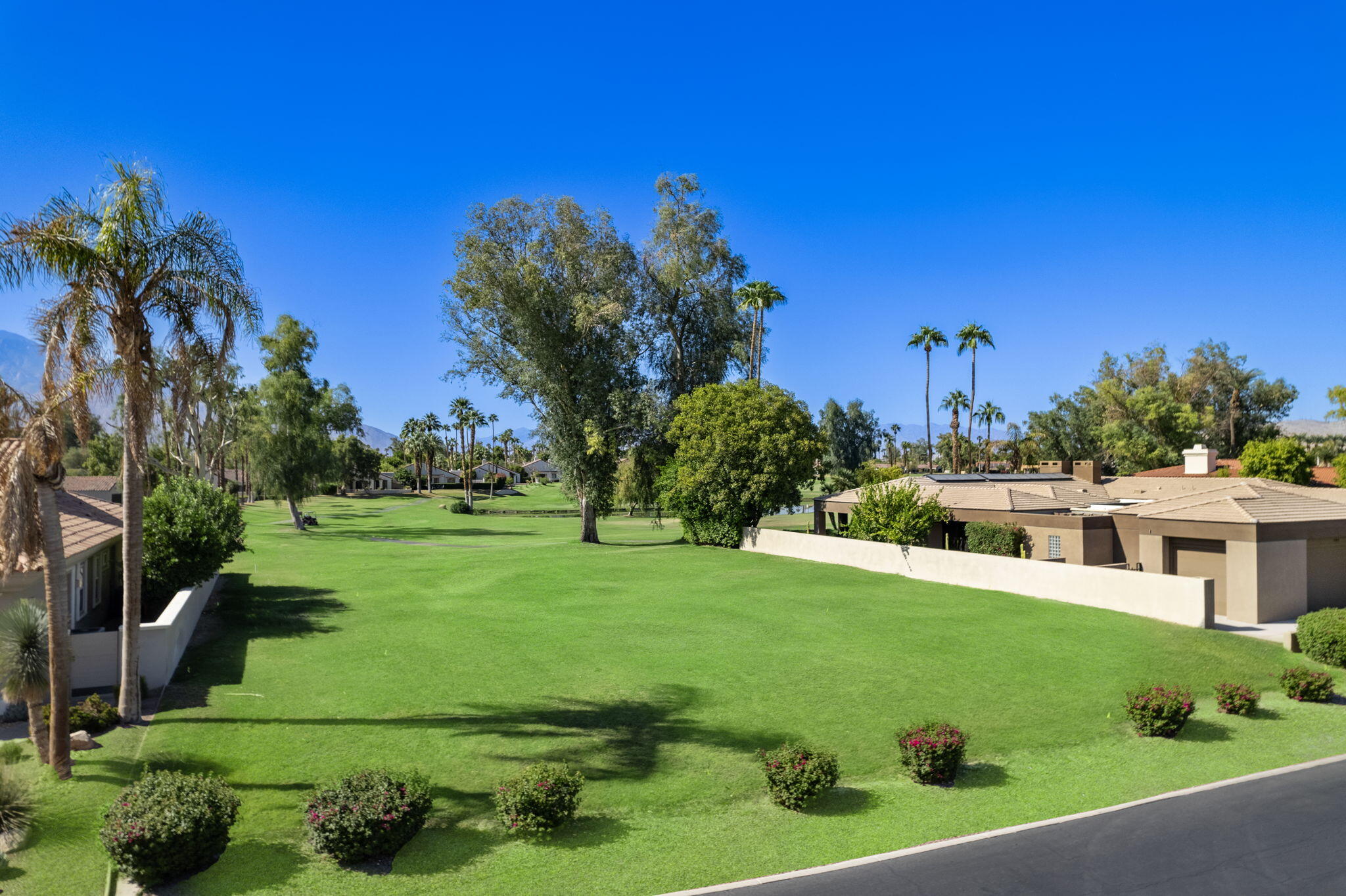 12102 Turnberry Drive Rancho Mirage, CA 92270 - Photo 9 of 28 a view of a white house with a big yard and potted plants