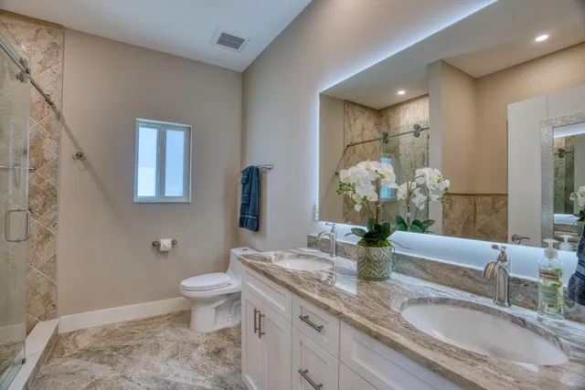 a bathroom with a granite countertop shower a sink and a mirror