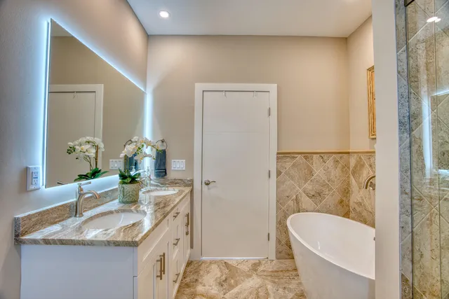 a bathroom with a granite countertop shower a mirror and a sink