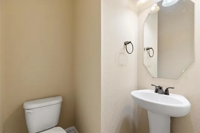 a bathroom with a toilet sink and mirror