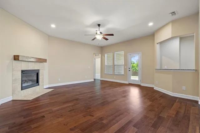 a view of an empty room with a fireplace and a window