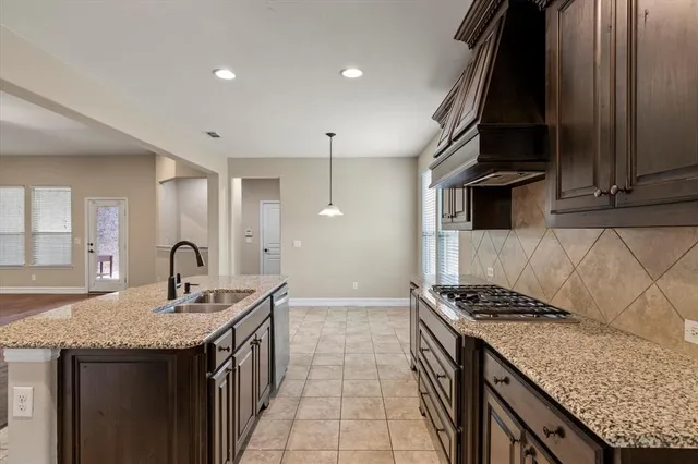 a kitchen with granite countertop stainless steel appliances sink stove and cabinets