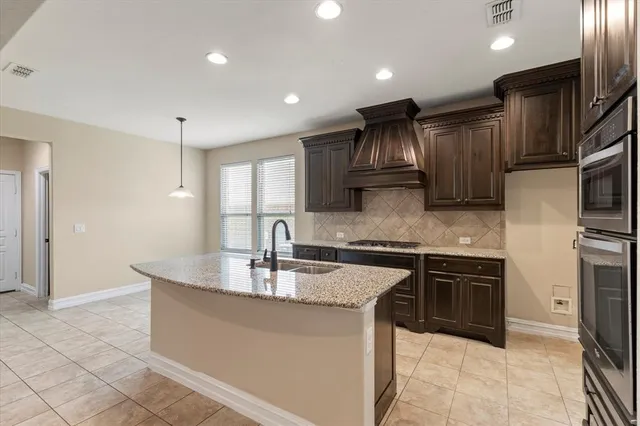 a kitchen with stainless steel appliances granite countertop a sink a stove and a refrigerator