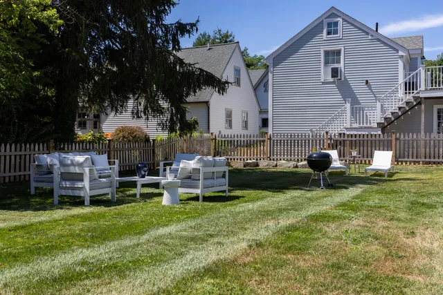 a view of a house with backyard and sitting area