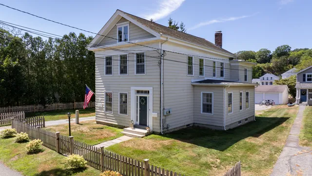 a view of a white house with a yard patio and furniture