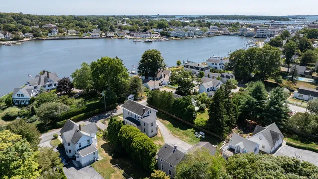 an aerial view of a residential houses with outdoor space and lake view