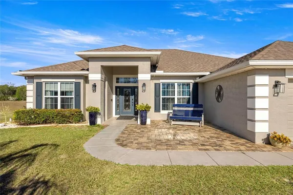 a view of a house with backyard and sitting area
