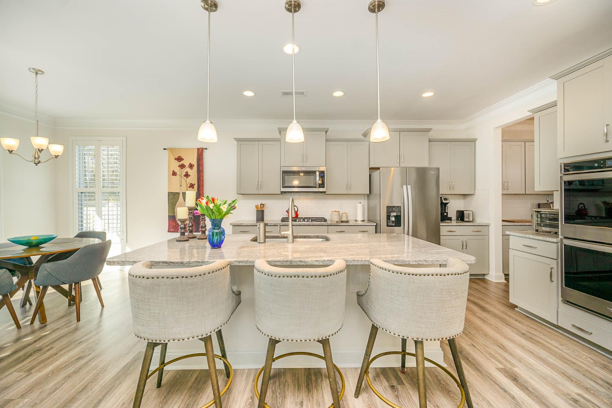 6029 Redwood Pine Road Concord, NC 28027 - Photo 12 of 48 a kitchen with a dining table chairs sink and cabinets