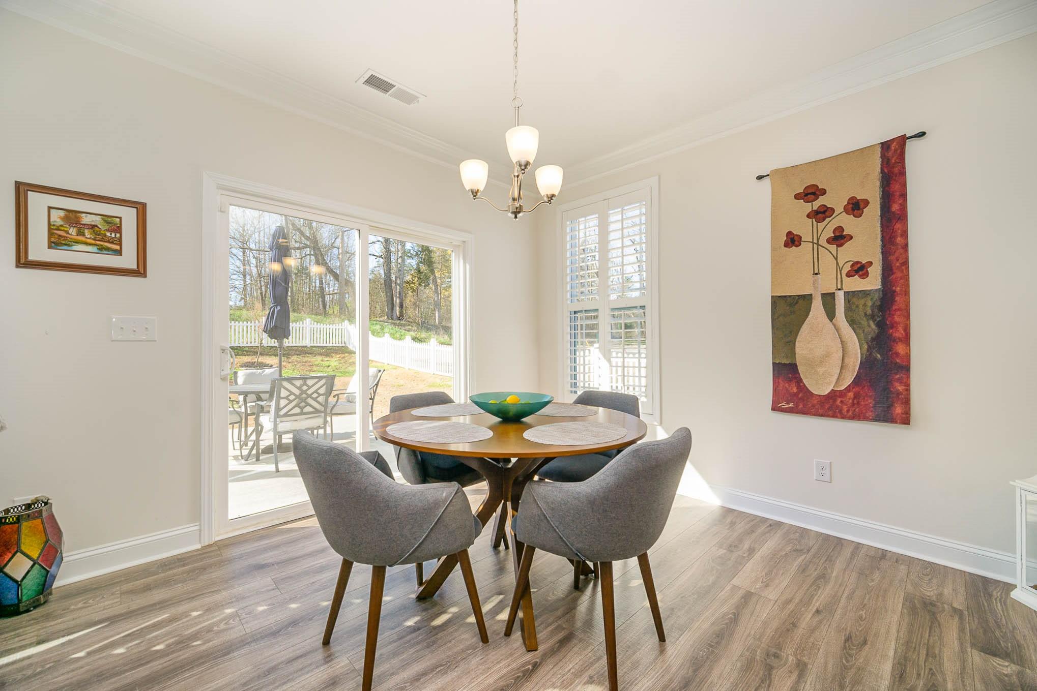 6029 Redwood Pine Road Concord, NC 28027 - Photo 17 of 48 a dining room with furniture a chandelier and wooden floor