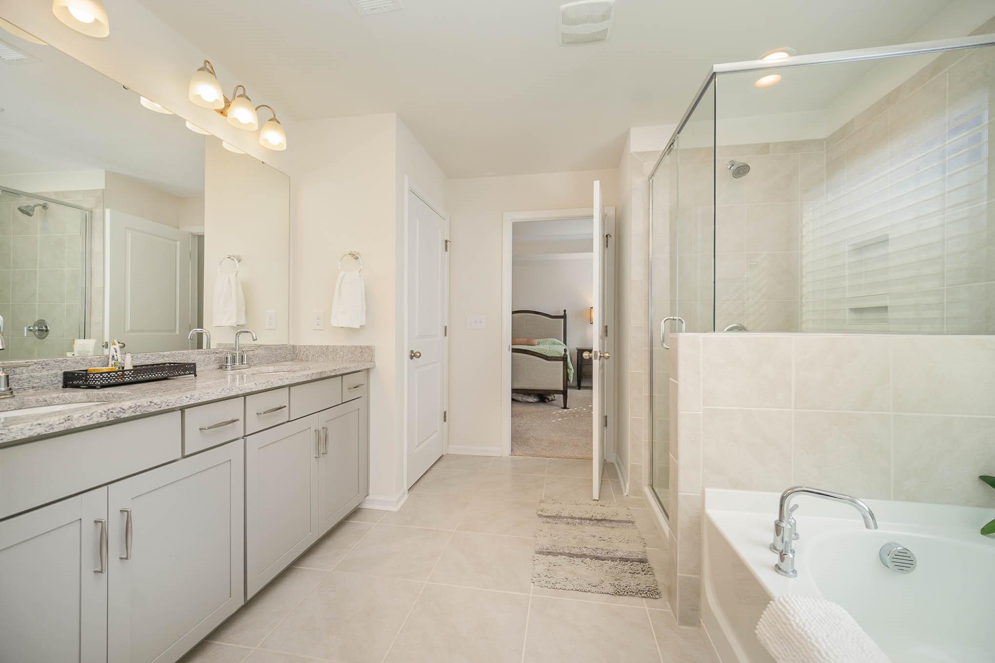 6029 Redwood Pine Road Concord, NC 28027 - Photo 22 of 48 a spacious bathroom with a granite countertop sink a mirror a shower and a bathtub