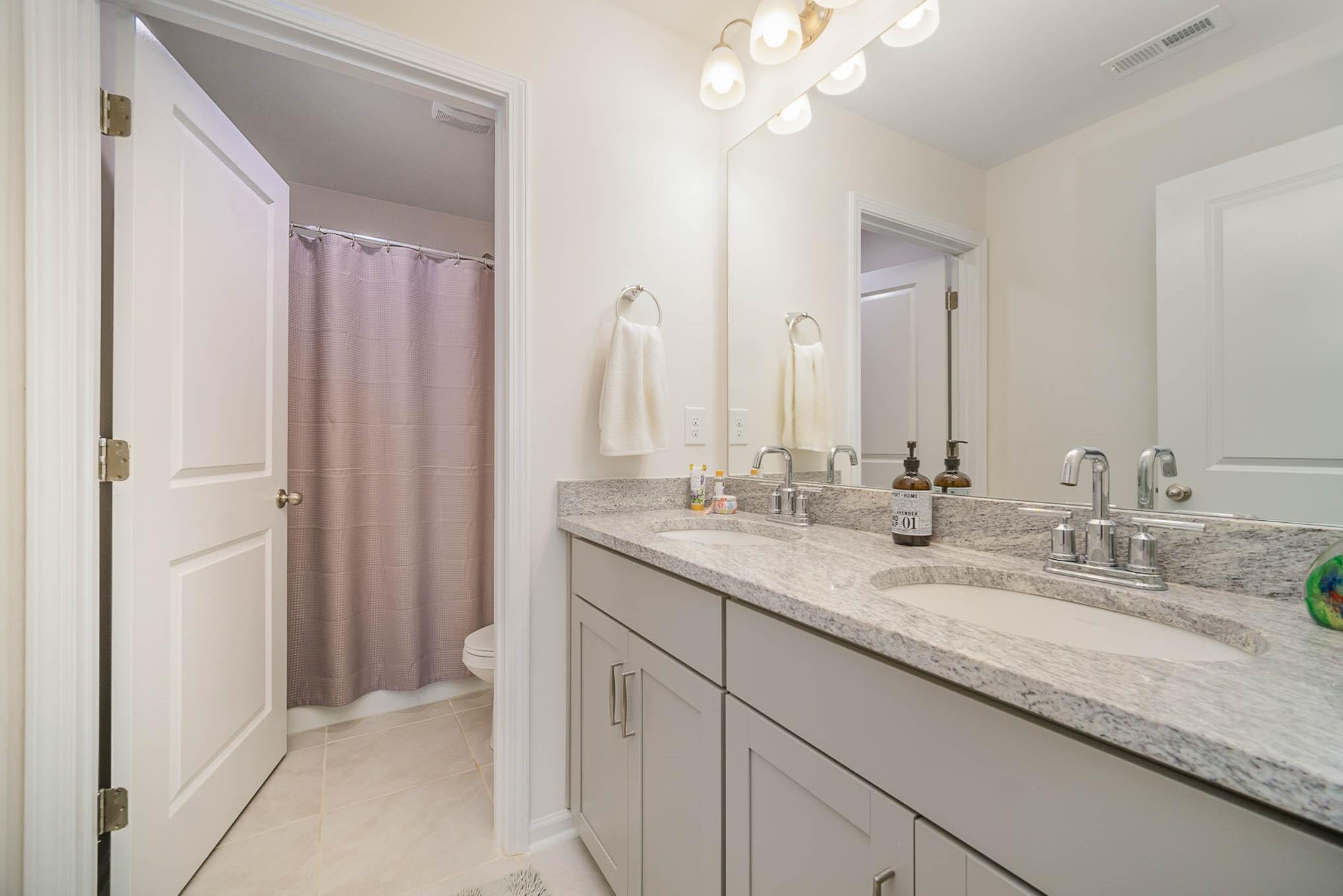 6029 Redwood Pine Road Concord, NC 28027 - Photo 29 of 48 a bathroom with double sink and a mirror