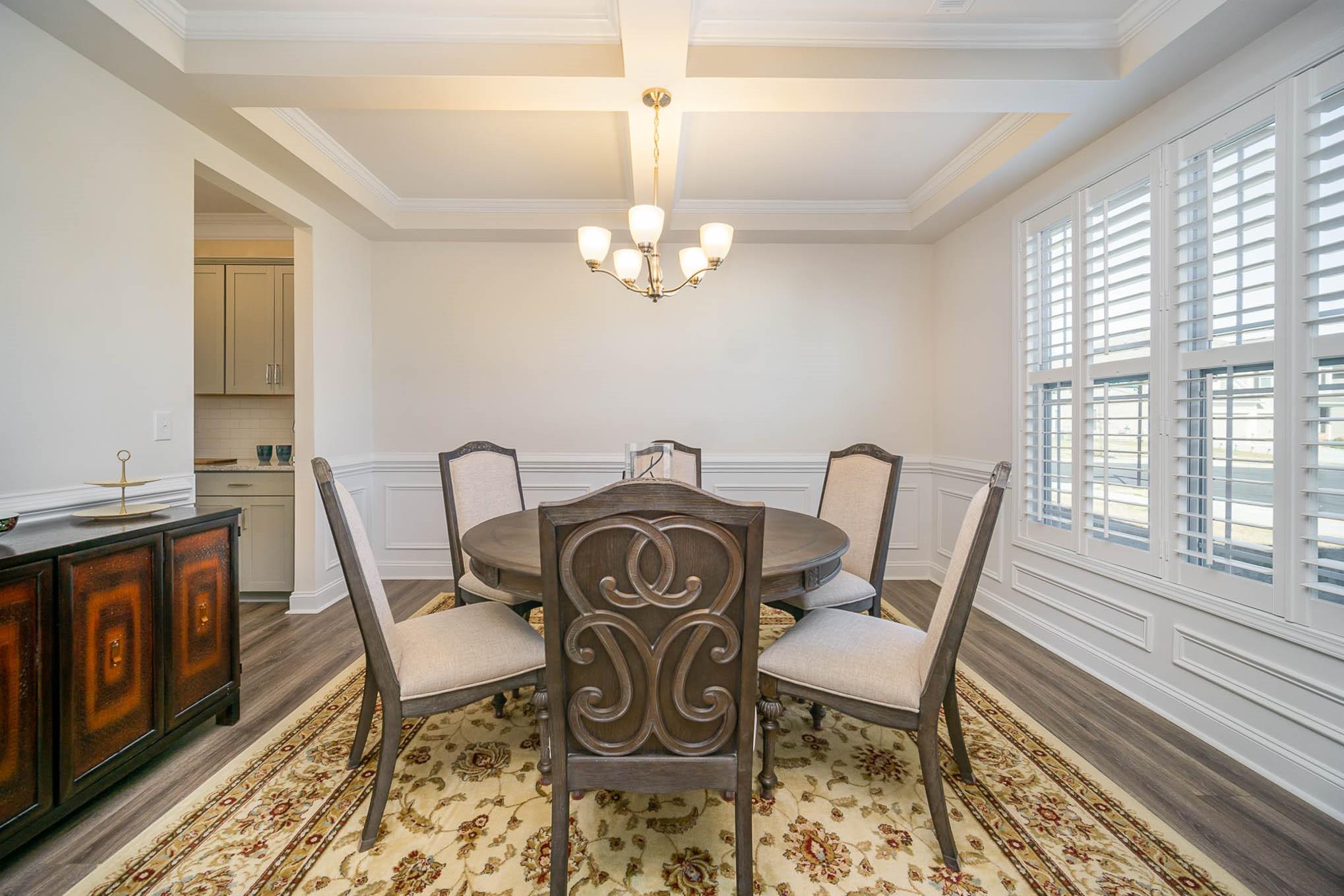 6029 Redwood Pine Road Concord, NC 28027 - Photo 7 of 48 a view of a dining room with furniture a chandelier and wooden floor
