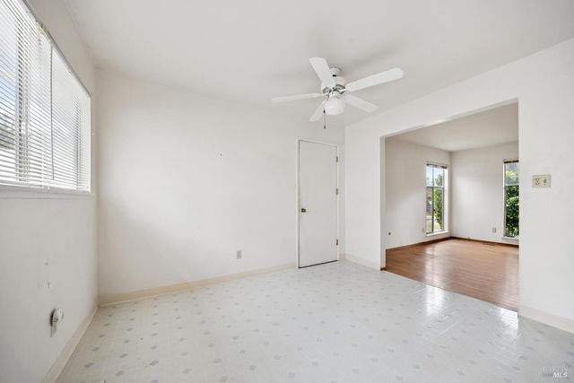 an empty room with fan and windows