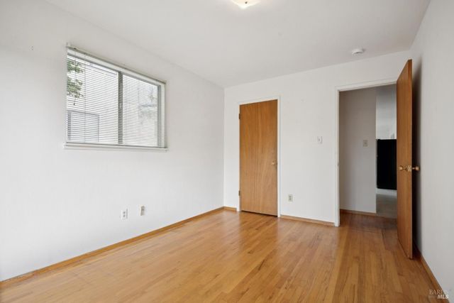 an empty room with wooden floor and closet