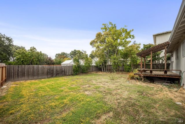 a backyard of a house with table and chairs