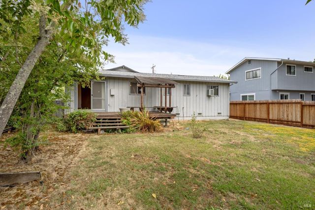 a backyard of a house with table and chairs