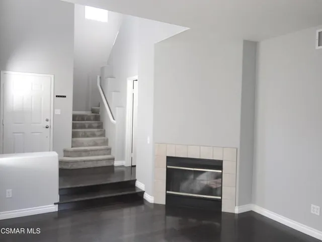 a view of an empty room with wooden floor and stairs
