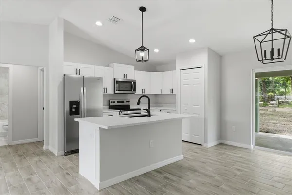 a view of kitchen with sink microwave refrigerator and cabinets