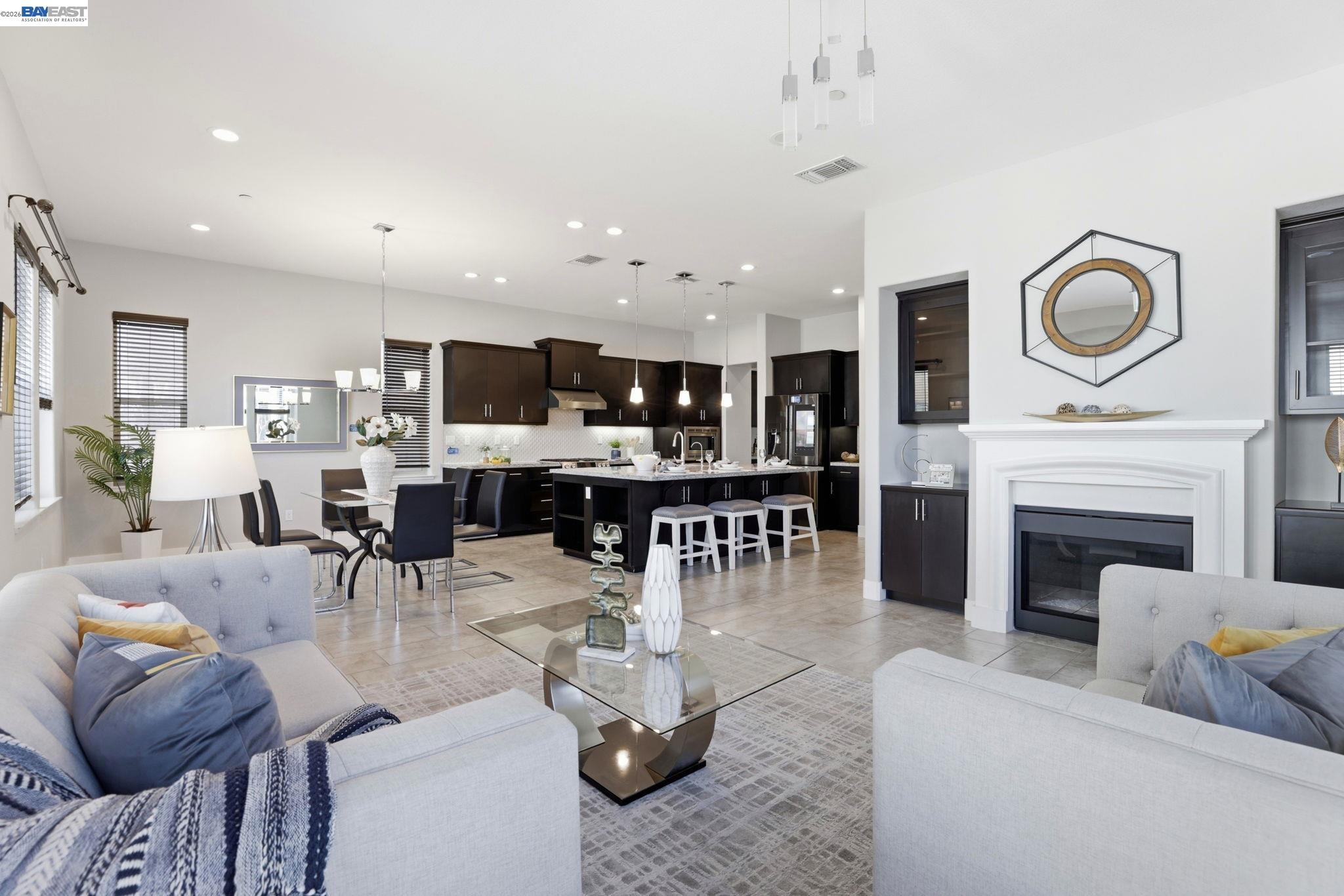 a living room with furniture a fireplace and kitchen view