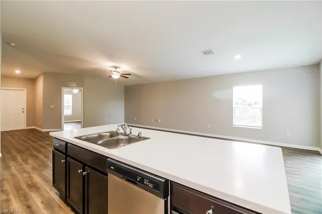 a close view of kitchen island a sink dishwasher and stove with wooden floor