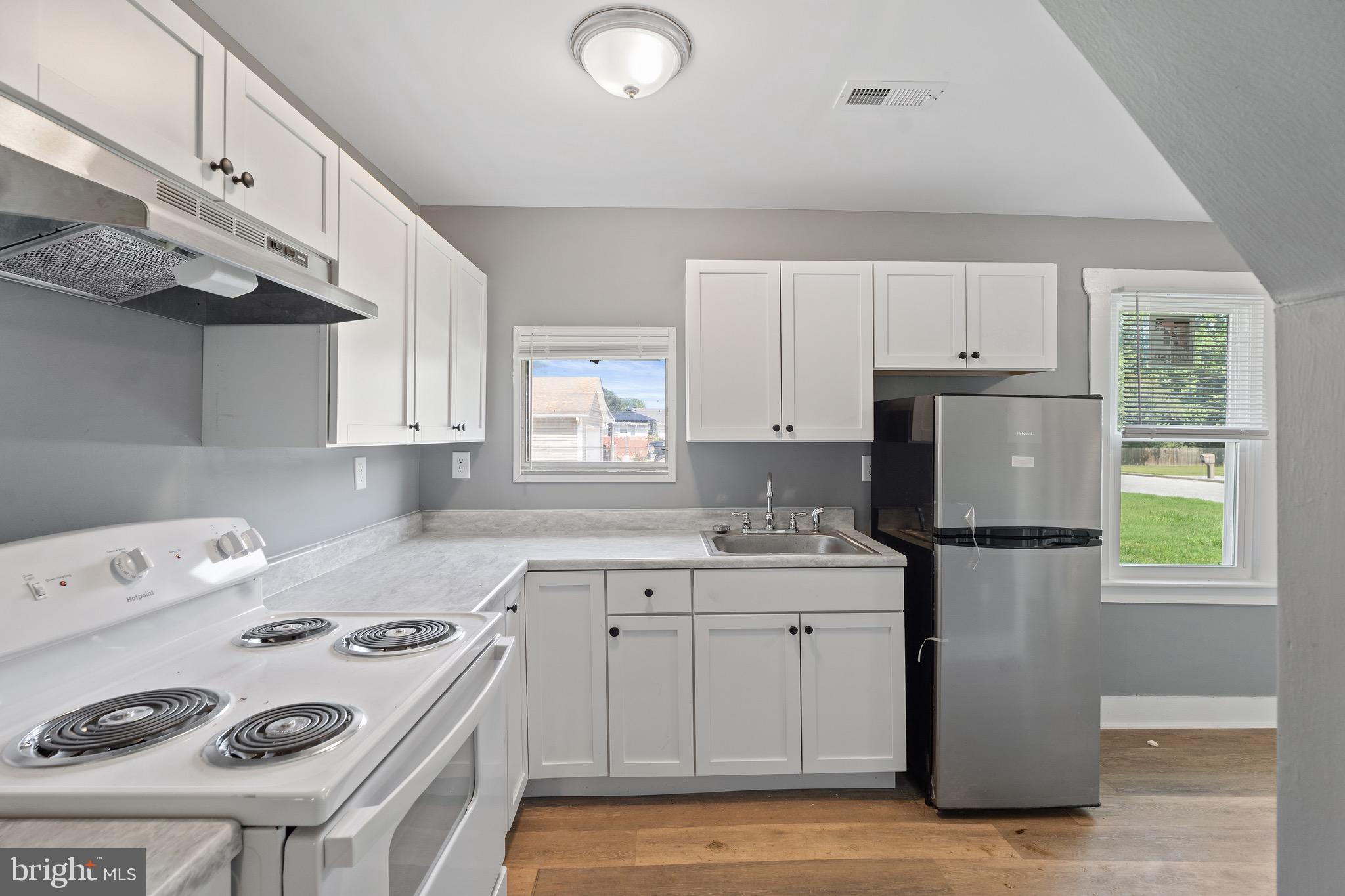 109 Georgia Road Pennsville, NJ 08070 - Photo 16 of 40 a kitchen with a white cabinets stove and refrigerator