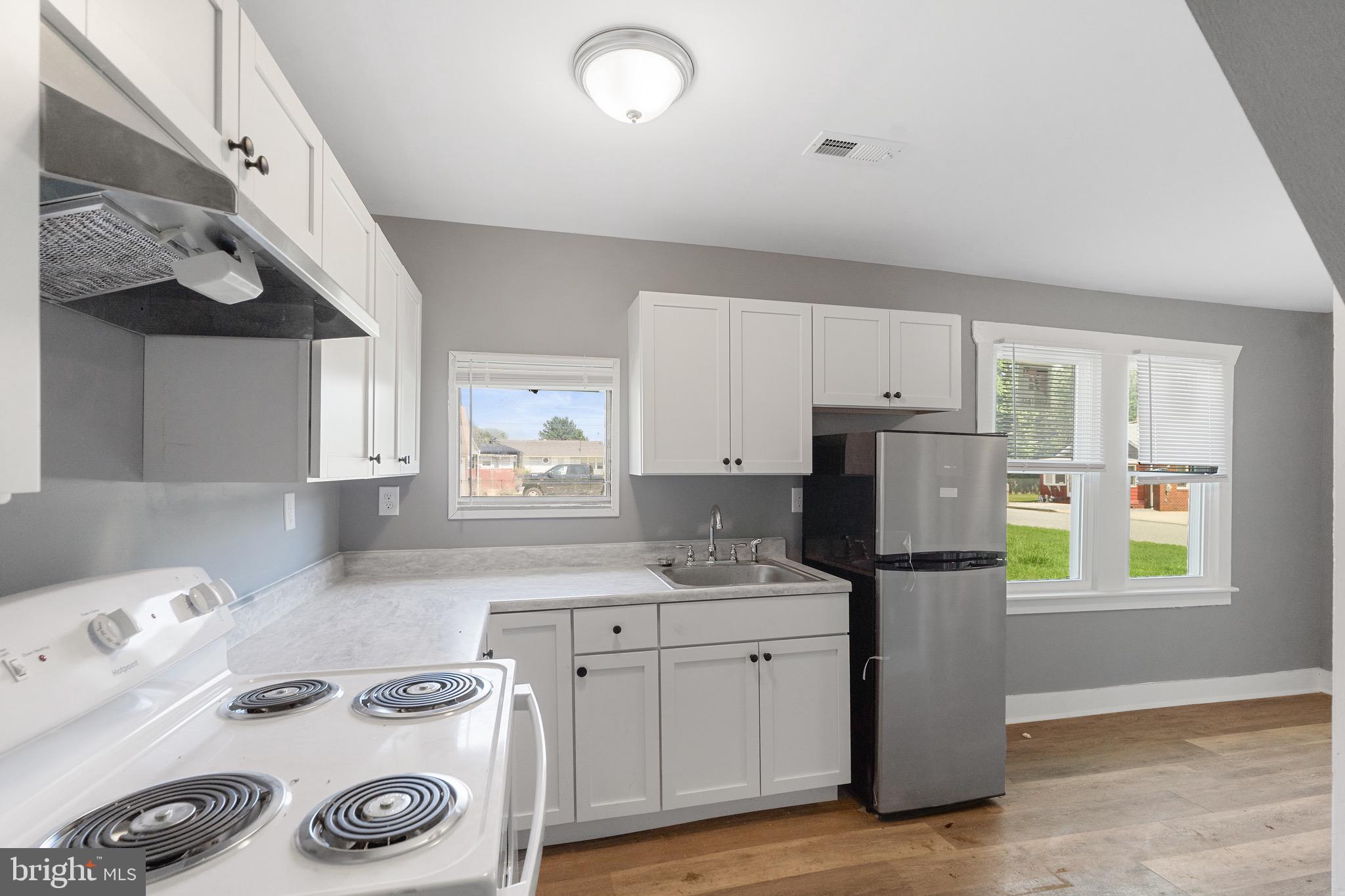 109 Georgia Road Pennsville, NJ 08070 - Photo 20 of 40 a kitchen with granite countertop a sink a refrigerator and wooden cabinets
