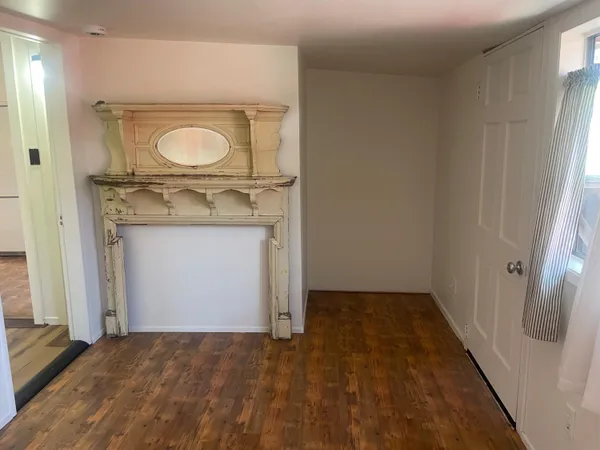 an empty room with wooden door and mirror