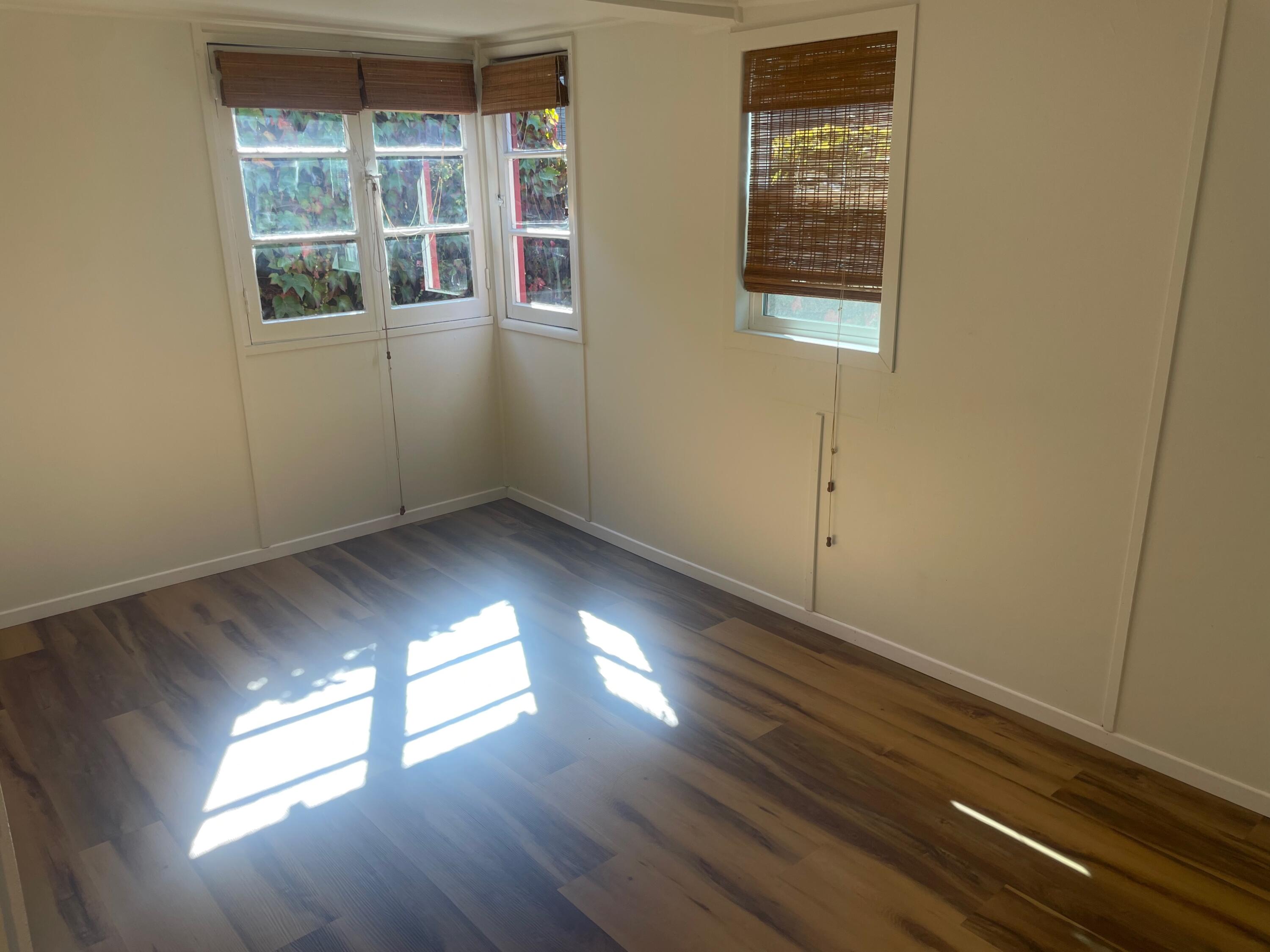 5161 6th Street Carpinteria, CA 93013 - Photo 21 of 27 an empty room with wooden floor and windows