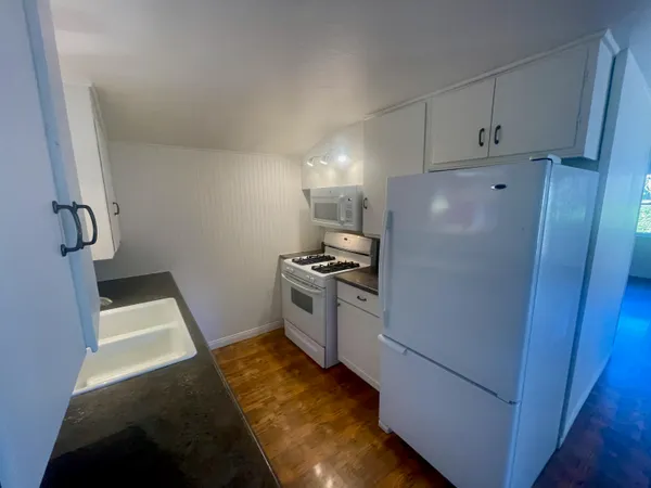 a kitchen with a refrigerator stove and white cabinets