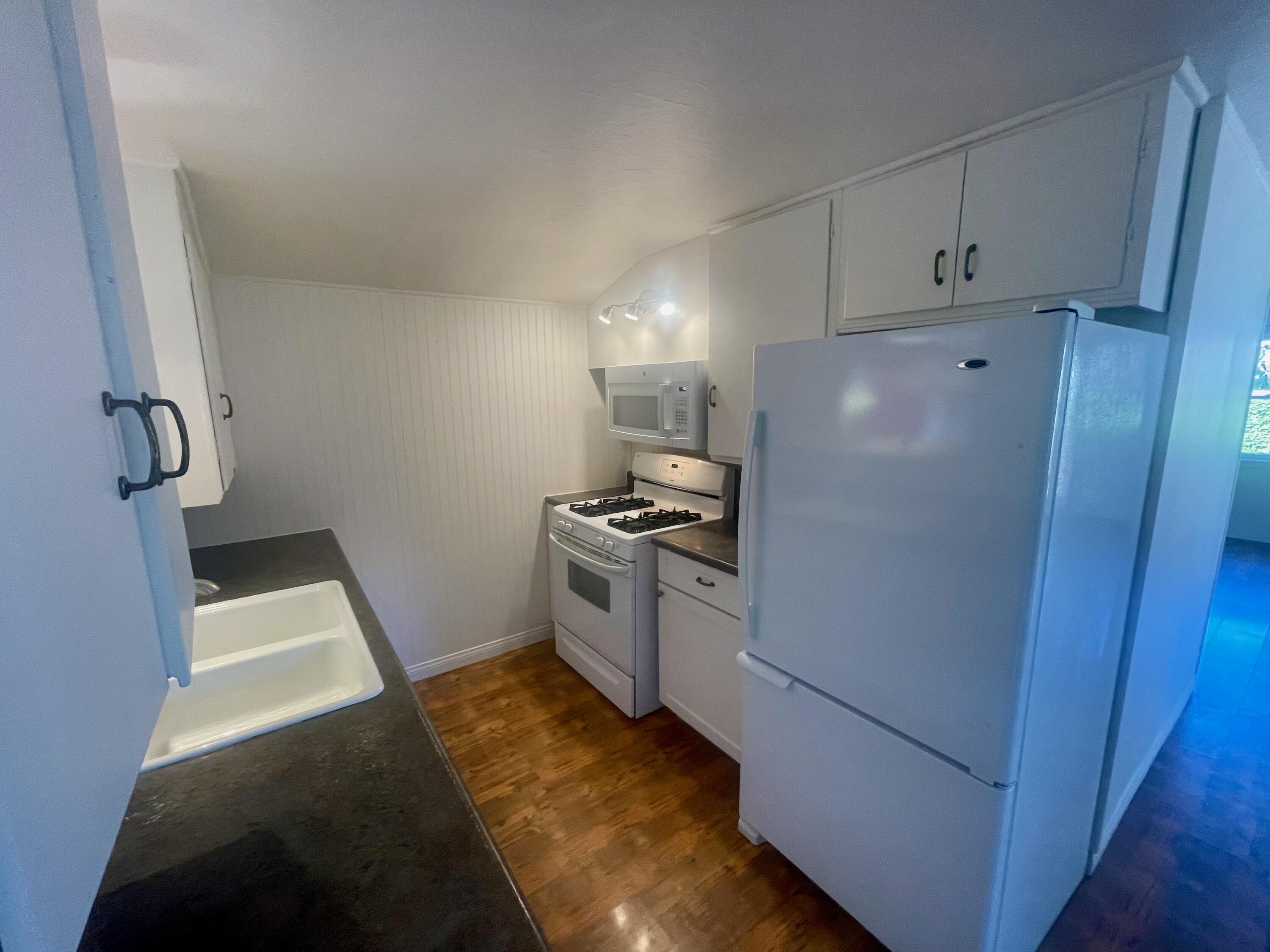 5161 6th Street Carpinteria, CA 93013 - Photo 5 of 27 a kitchen with a refrigerator stove and white cabinets