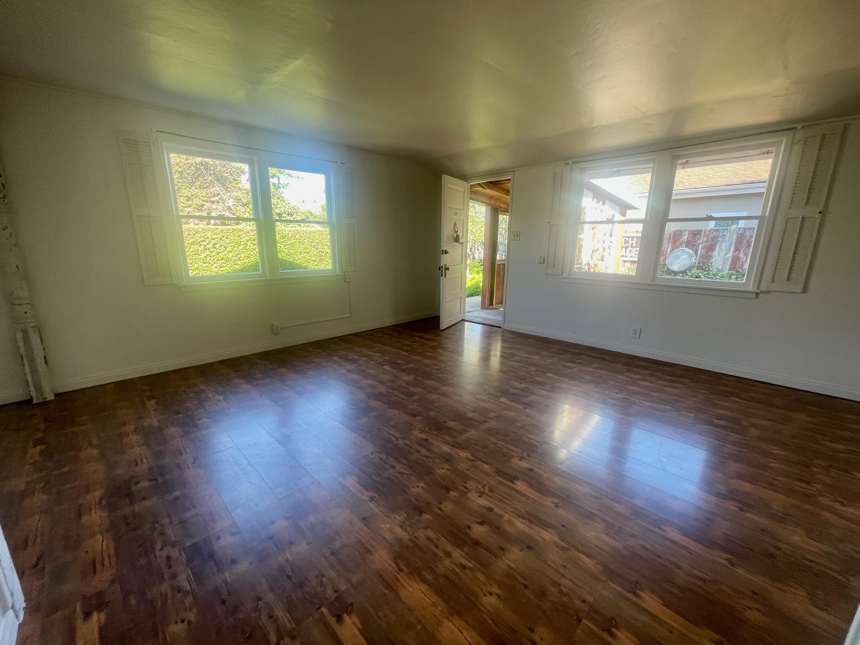 5161 6th Street Carpinteria, CA 93013 - Photo 9 of 27 an empty room with wooden floor and windows