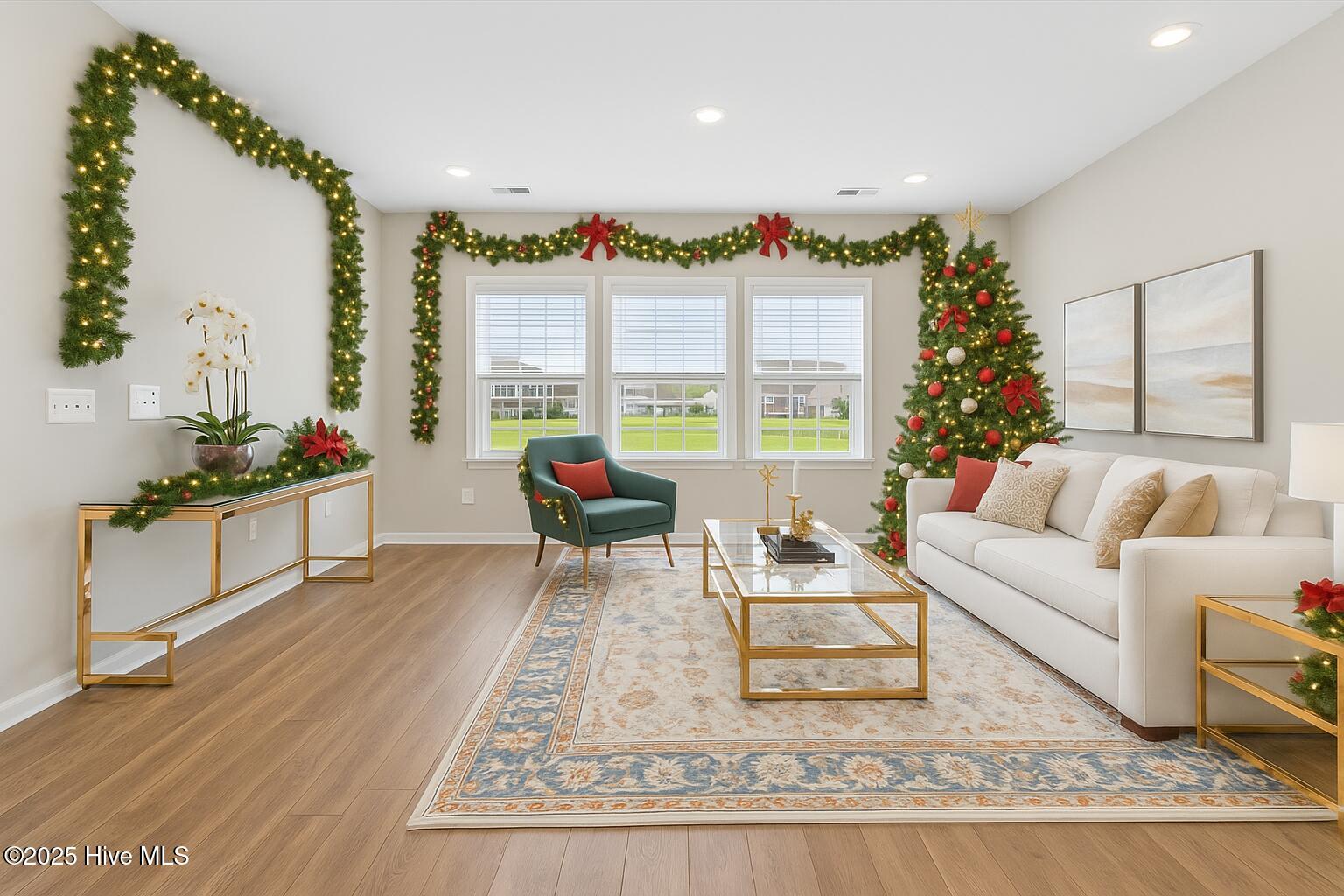 9355 Eagle Rdg Drive Calabash, NC 28467 - Photo 4 of 83 Virtually staged. Sophisticated holiday-decorated living room featuring classic garland, a beautifully lit Christmas tree, and natural daylight—perfectly capturing the luxurious coastal lifestyle at 9355 Eagle Ridge Drive.