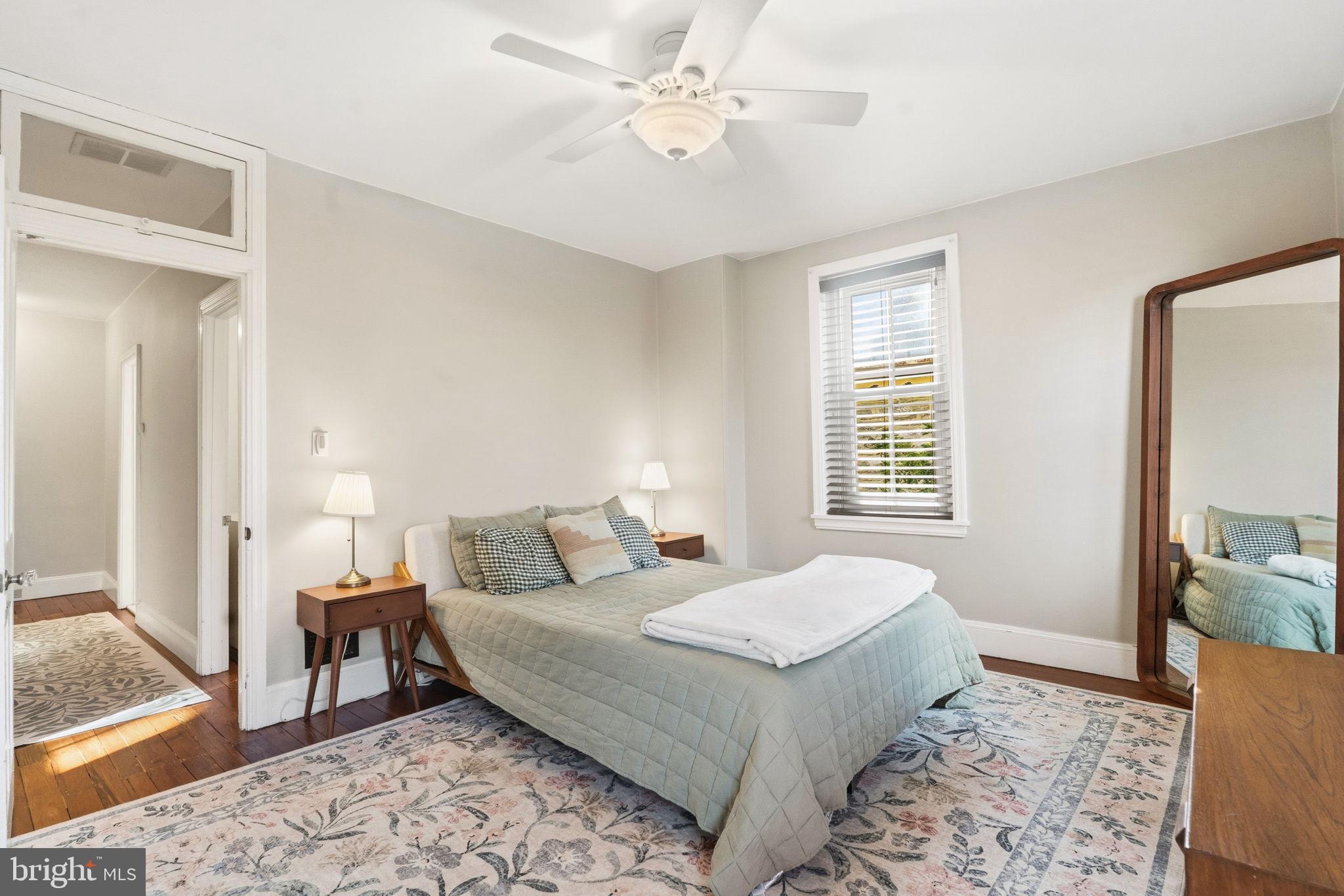 212 Benezet Street Philadelphia, PA 19118 - Photo 14 of 32 a bedroom with a bed and wooden floor