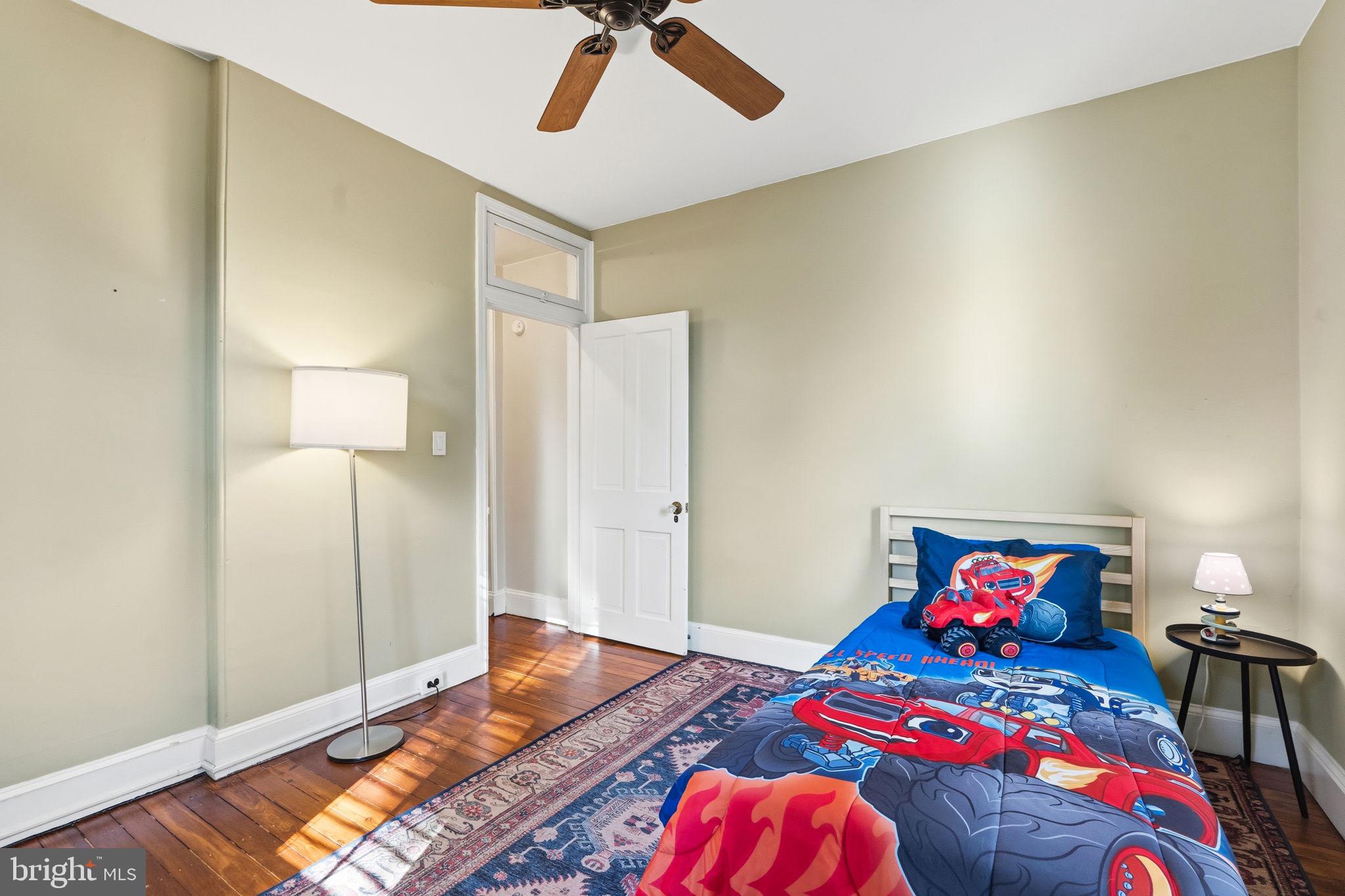 212 Benezet Street Philadelphia, PA 19118 - Photo 19 of 32 a bedroom with a bed and wooden floor