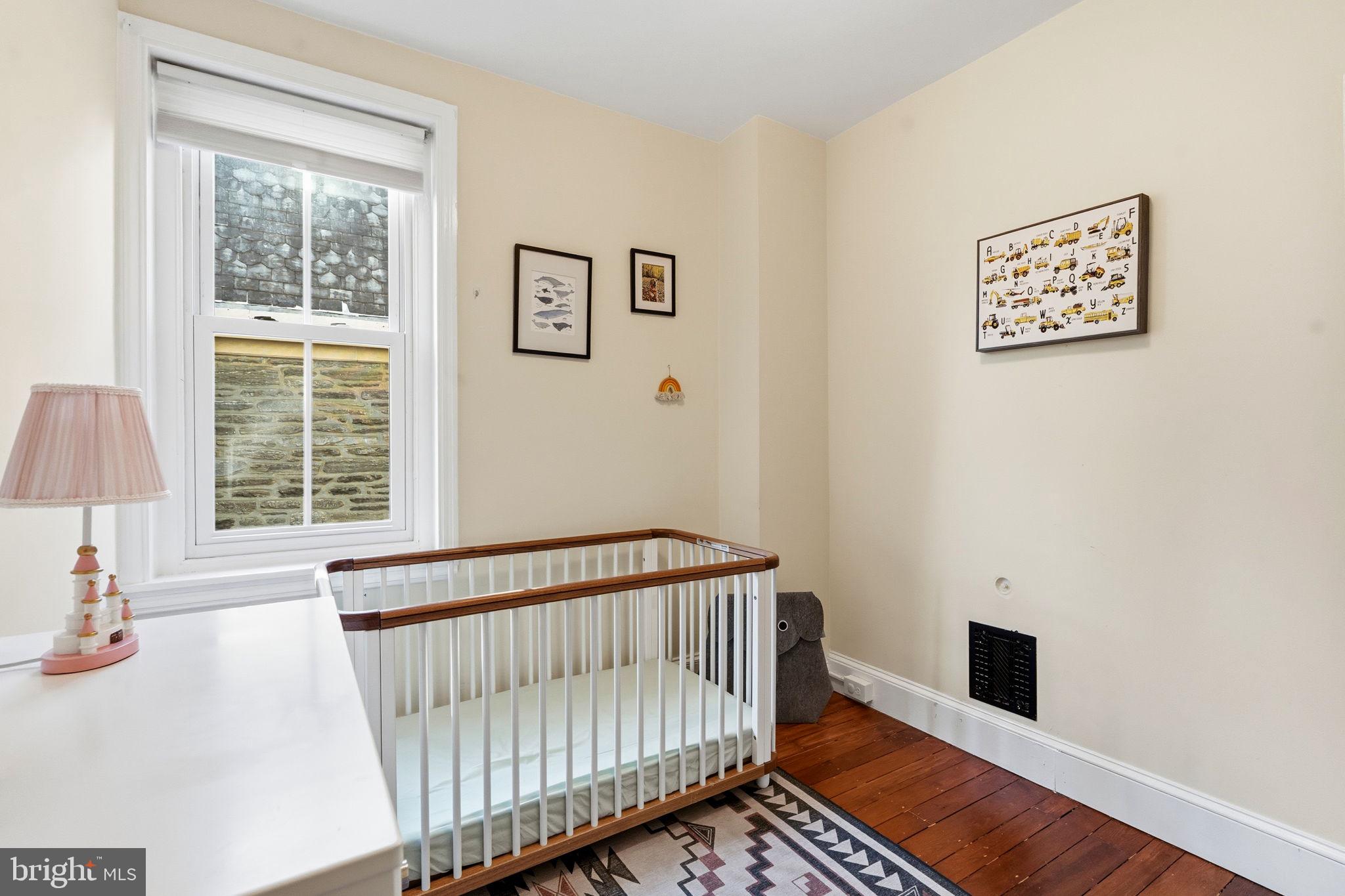212 Benezet Street Philadelphia, PA 19118 - Photo 23 of 32 a view of a bedroom with wooden floor & windows