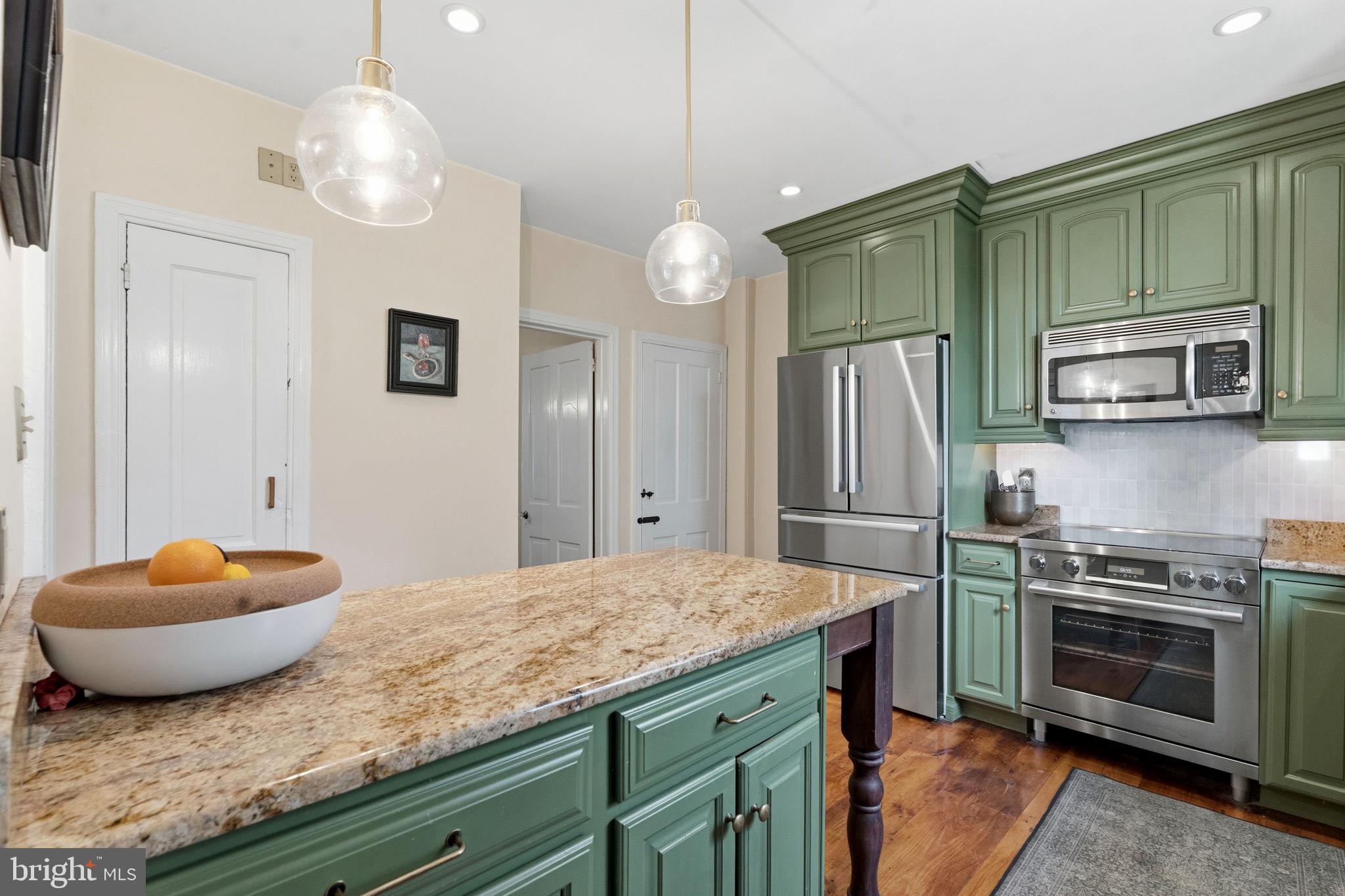 212 Benezet Street Philadelphia, PA 19118 - Photo 8 of 32 a kitchen with stainless steel appliances granite countertop a stove refrigerator and microwave