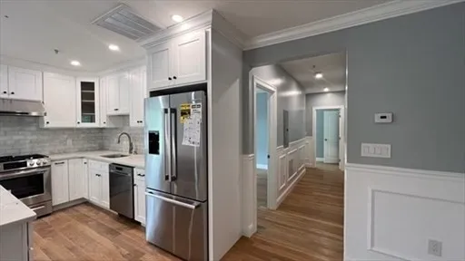 a kitchen with stainless steel appliances granite countertop a refrigerator and a sink